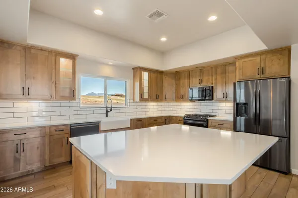 a large kitchen with stainless steel appliances and a view of kitchen