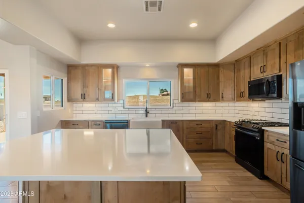 a large kitchen with cabinets wooden floor and stainless steel appliances
