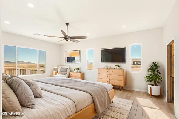 an empty room with wooden floor cabinet and windows