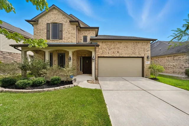 a front view of a house with a garden and plants