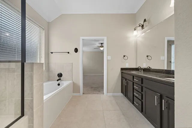 a spacious bathroom with a tub sink shower and mirror
