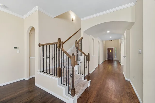 a view of a hallway with wooden floor and stairs