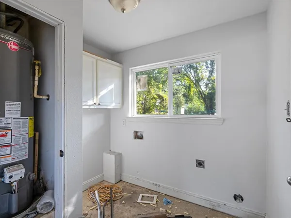 a view of a livingroom with a chandelier fan and windows
