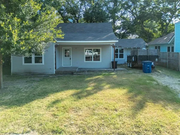 a view of a house with backyard and trees