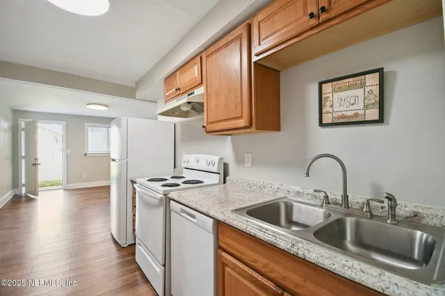 a kitchen with stainless steel appliances granite countertop a sink a stove and a refrigerator