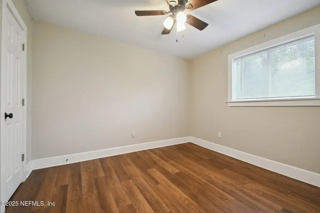 a view of a room with wooden floor and windows