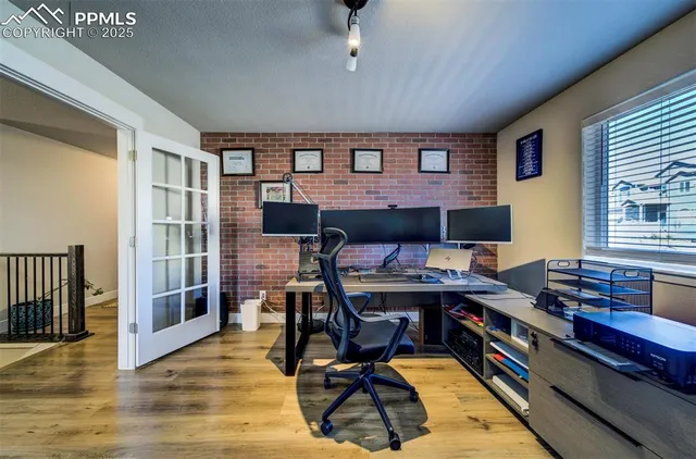 a view of a workspace with furniture and a window