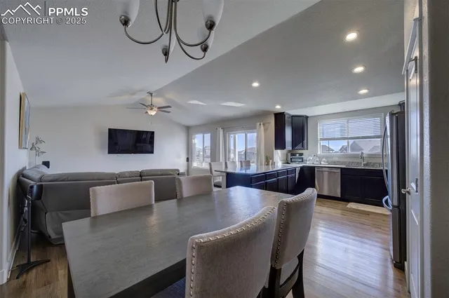 a view of kitchen and dining room with furniture a chandelier and wooden floor