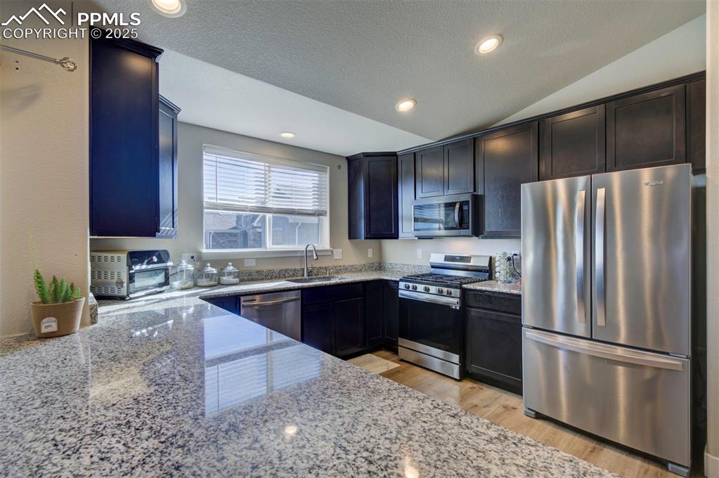 5489 Makalu Drive Colorado Springs, CO 80924 - Photo 22 of 47 a kitchen with granite countertop stainless steel appliances and wooden cabinets