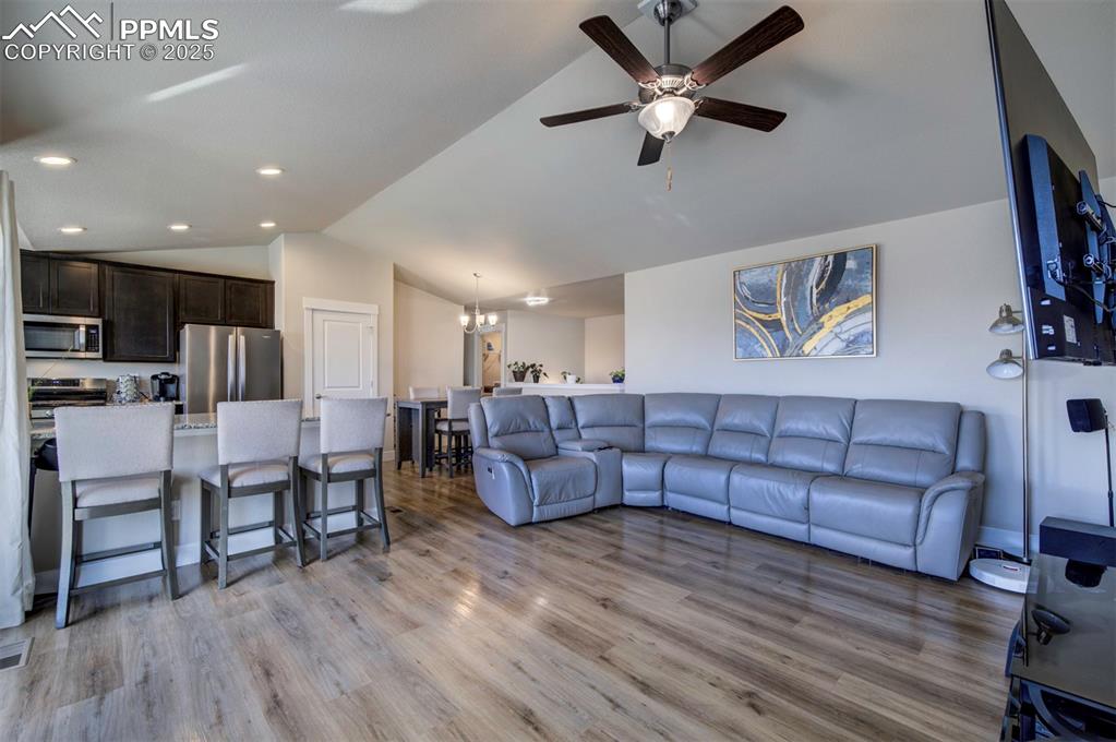5489 Makalu Drive Colorado Springs, CO 80924 - Photo 23 of 47 a living room with couches and kitchen view with wooden floor