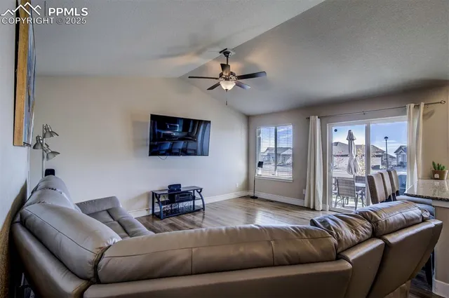 a living room with furniture and a ceiling fan