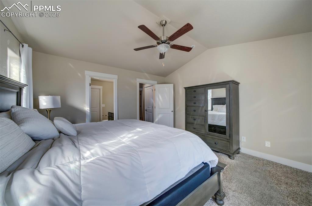 5489 Makalu Drive Colorado Springs, CO 80924 - Photo 28 of 47 a bedroom with a large bed and a chandelier