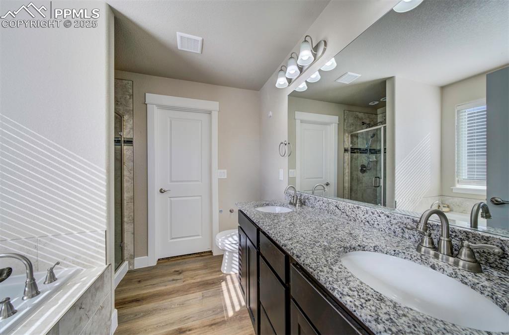 5489 Makalu Drive Colorado Springs, CO 80924 - Photo 29 of 47 a bathroom with a granite countertop sink a large mirror and a shower