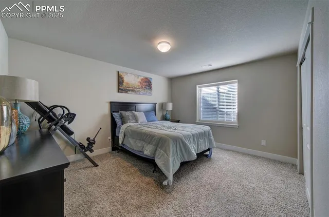a bedroom with a bed and a flat tv screen on the dresser