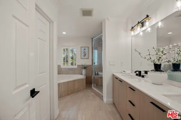 a bathroom with a sink a tub and a mirror