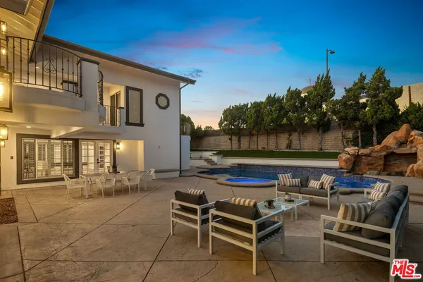 a view of a chairs and tables in the back yard of the building