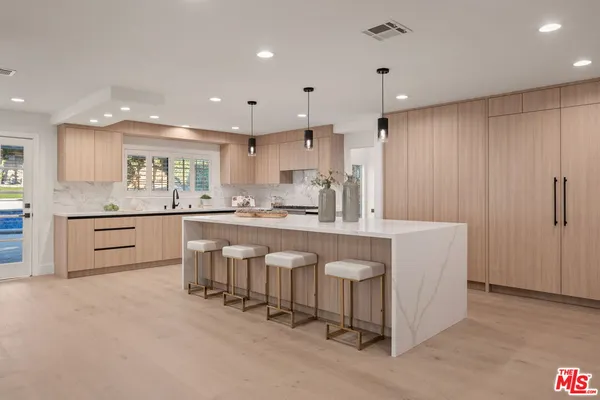 a kitchen with white cabinets and sink
