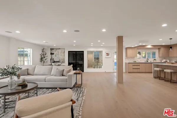 a living room with furniture white walls and kitchen view