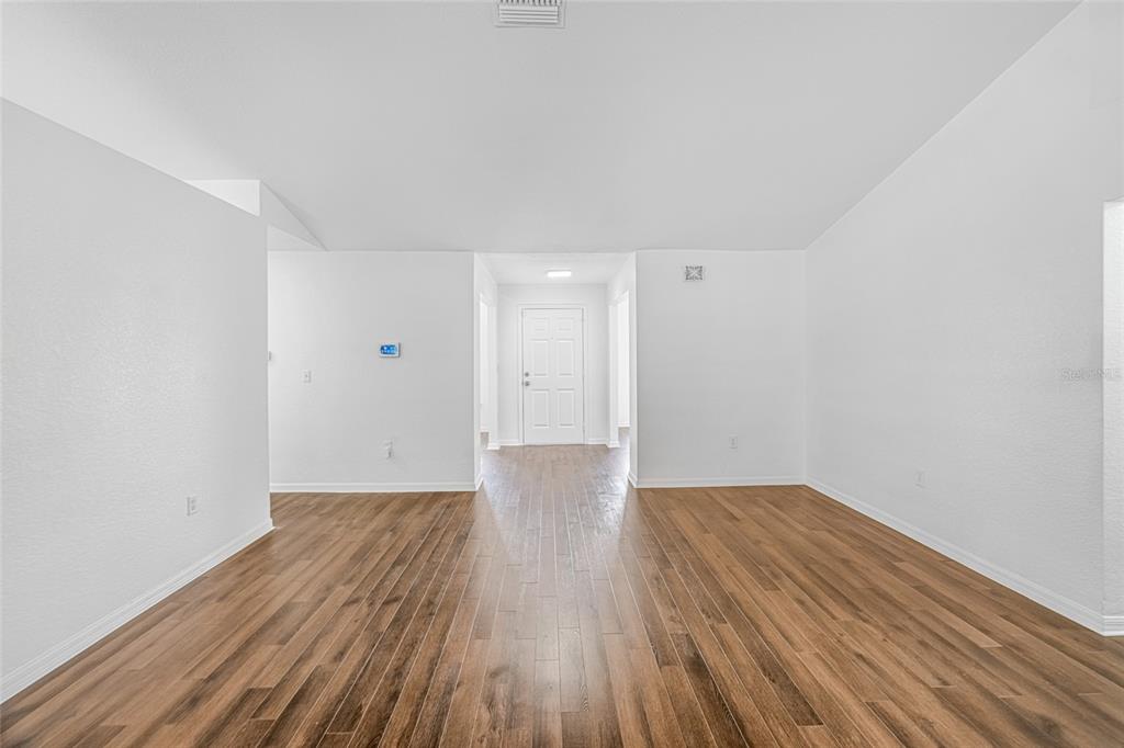 418 Windermere Drive Lehigh Acres, FL 33972 - Photo 13 of 71 a view of a room with wooden floor and white walls