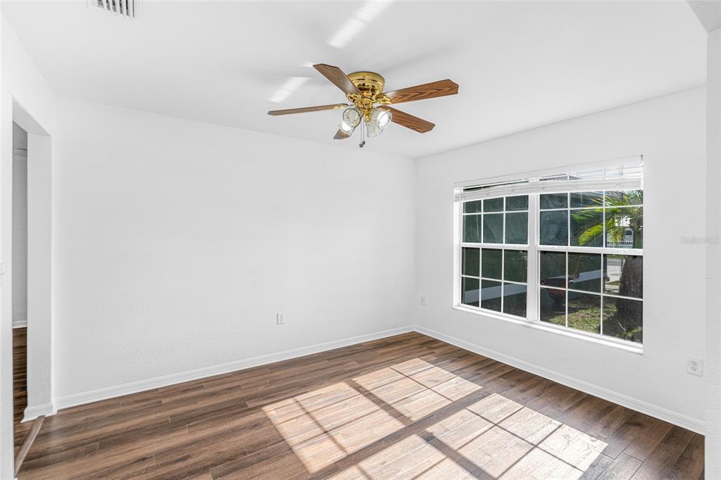 418 Windermere Drive Lehigh Acres, FL 33972 - Photo 16 of 71 an empty room with wooden floor and windows