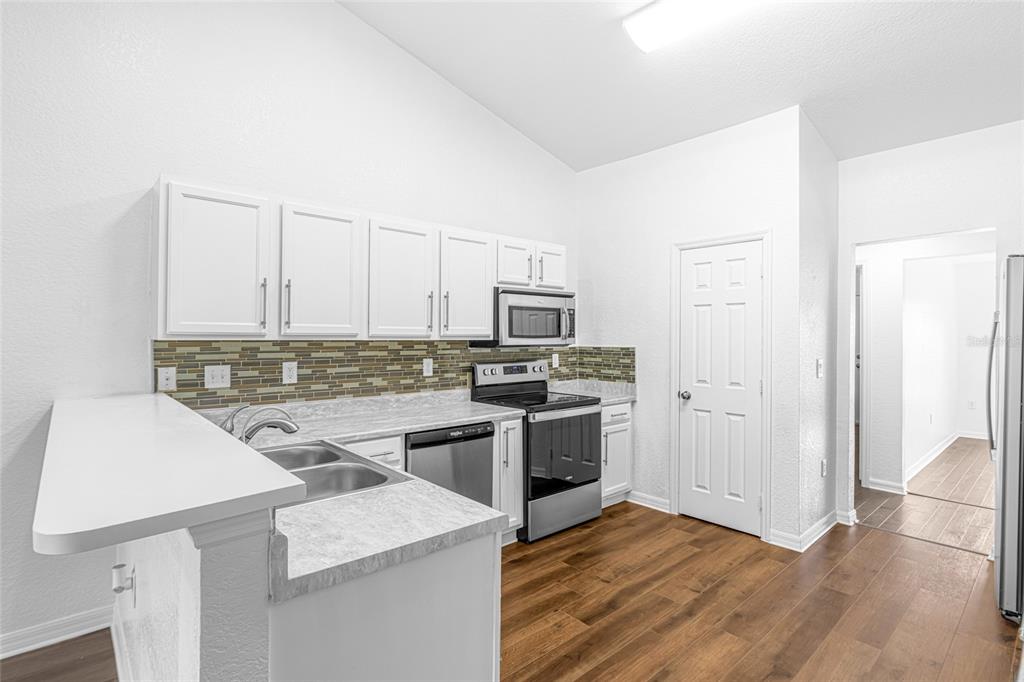 418 Windermere Drive Lehigh Acres, FL 33972 - Photo 28 of 71 a kitchen with a sink stove and refrigerator