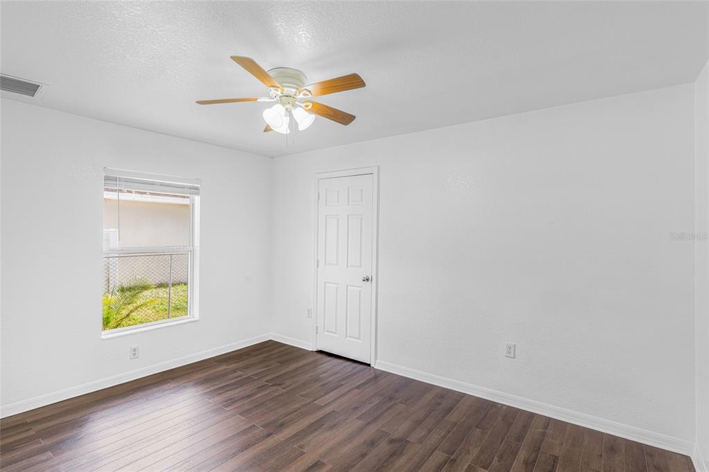 418 Windermere Drive Lehigh Acres, FL 33972 - Photo 32 of 71 an empty room with window and wooden floor