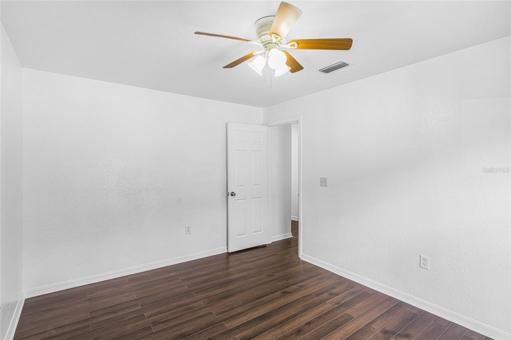 418 Windermere Drive Lehigh Acres, FL 33972 - Photo 33 of 71 a view of a room with wooden floor and white walls