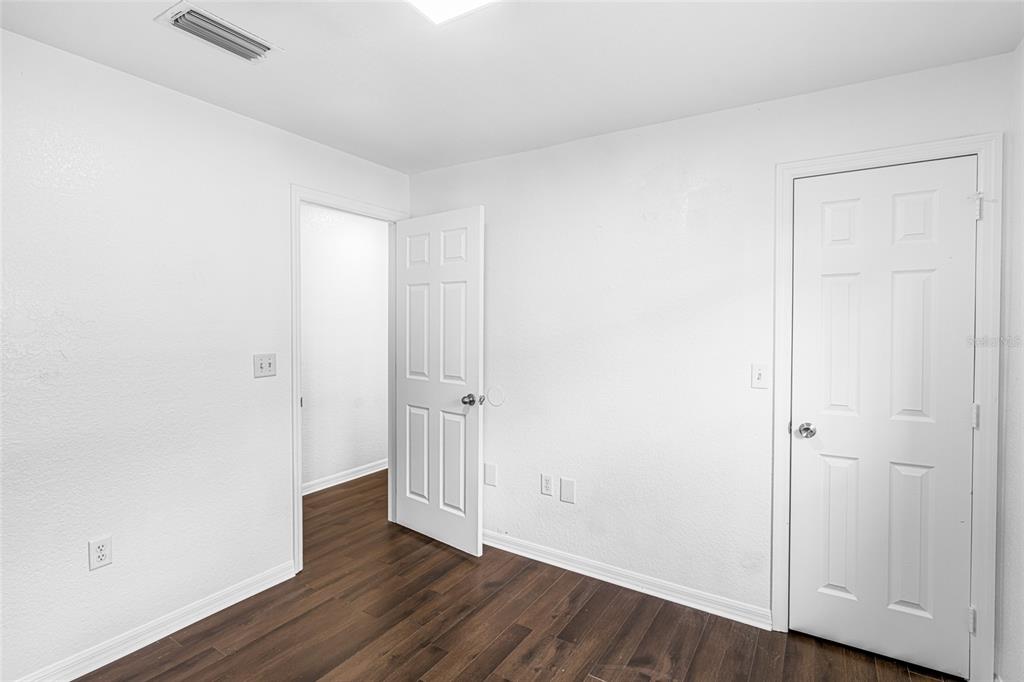418 Windermere Drive Lehigh Acres, FL 33972 - Photo 35 of 71 a view of an empty room with wooden floor