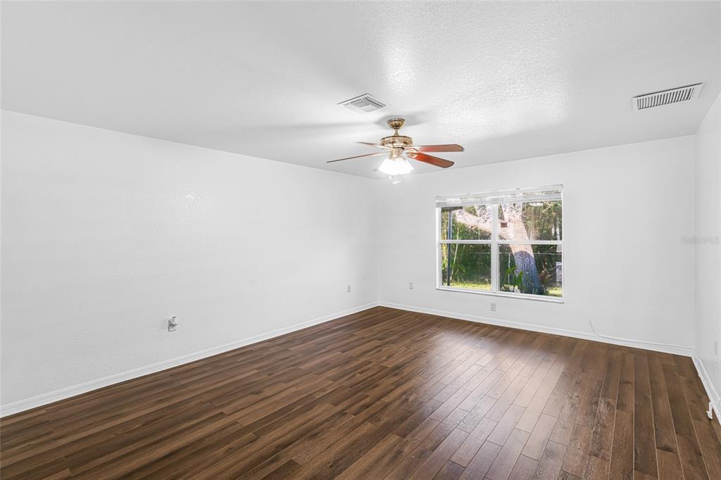 418 Windermere Drive Lehigh Acres, FL 33972 - Photo 39 of 71 wooden floor in an empty room with a window
