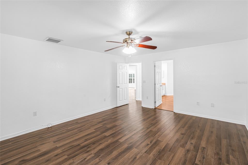 418 Windermere Drive Lehigh Acres, FL 33972 - Photo 40 of 71 a view of an empty room with wooden floor