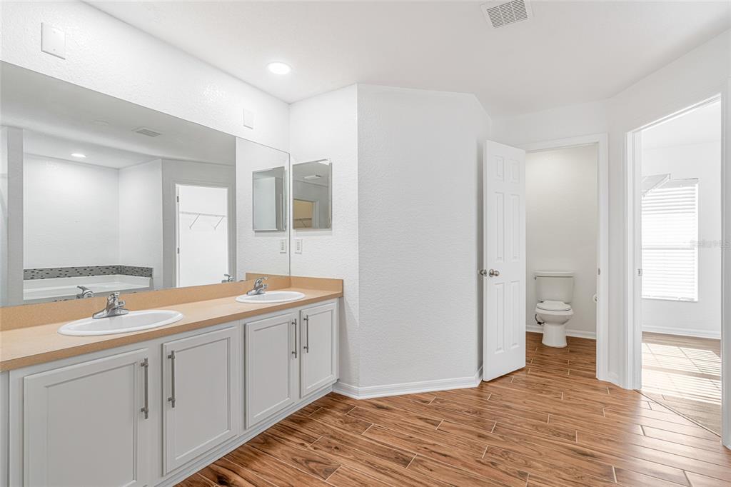 418 Windermere Drive Lehigh Acres, FL 33972 - Photo 44 of 71 a spacious bathroom with a double vanity sink a mirror and a toilet