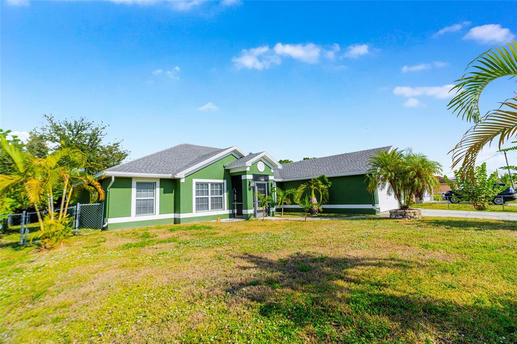 418 Windermere Drive Lehigh Acres, FL 33972 - Photo 8 of 71 a front view of a house with a yard and palm trees