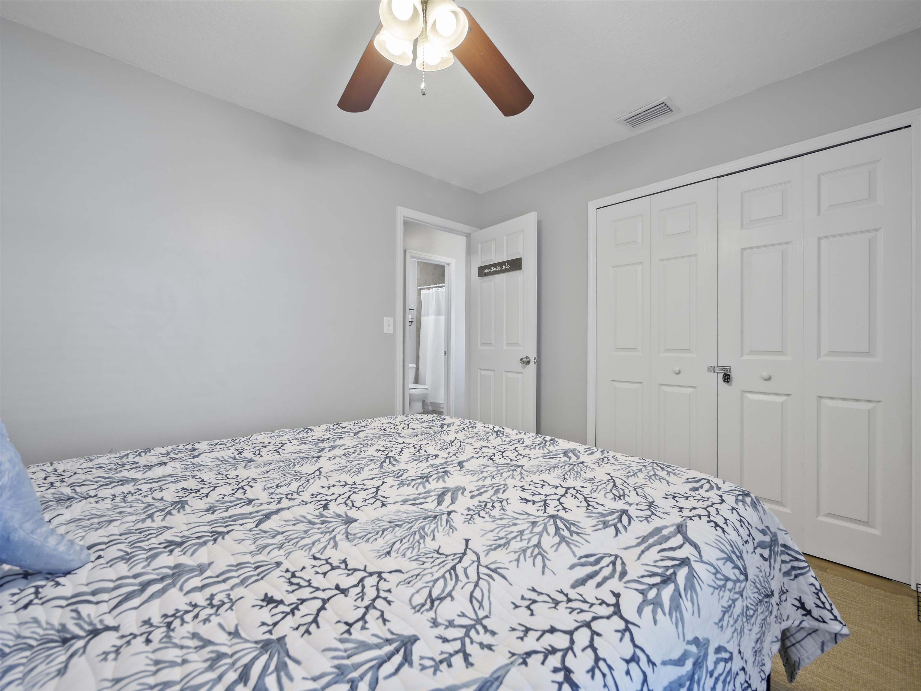 241 Tropic Way St. Augustine, FL 32080 - Photo 23 of 32 a bedroom with a large bed and a chandelier