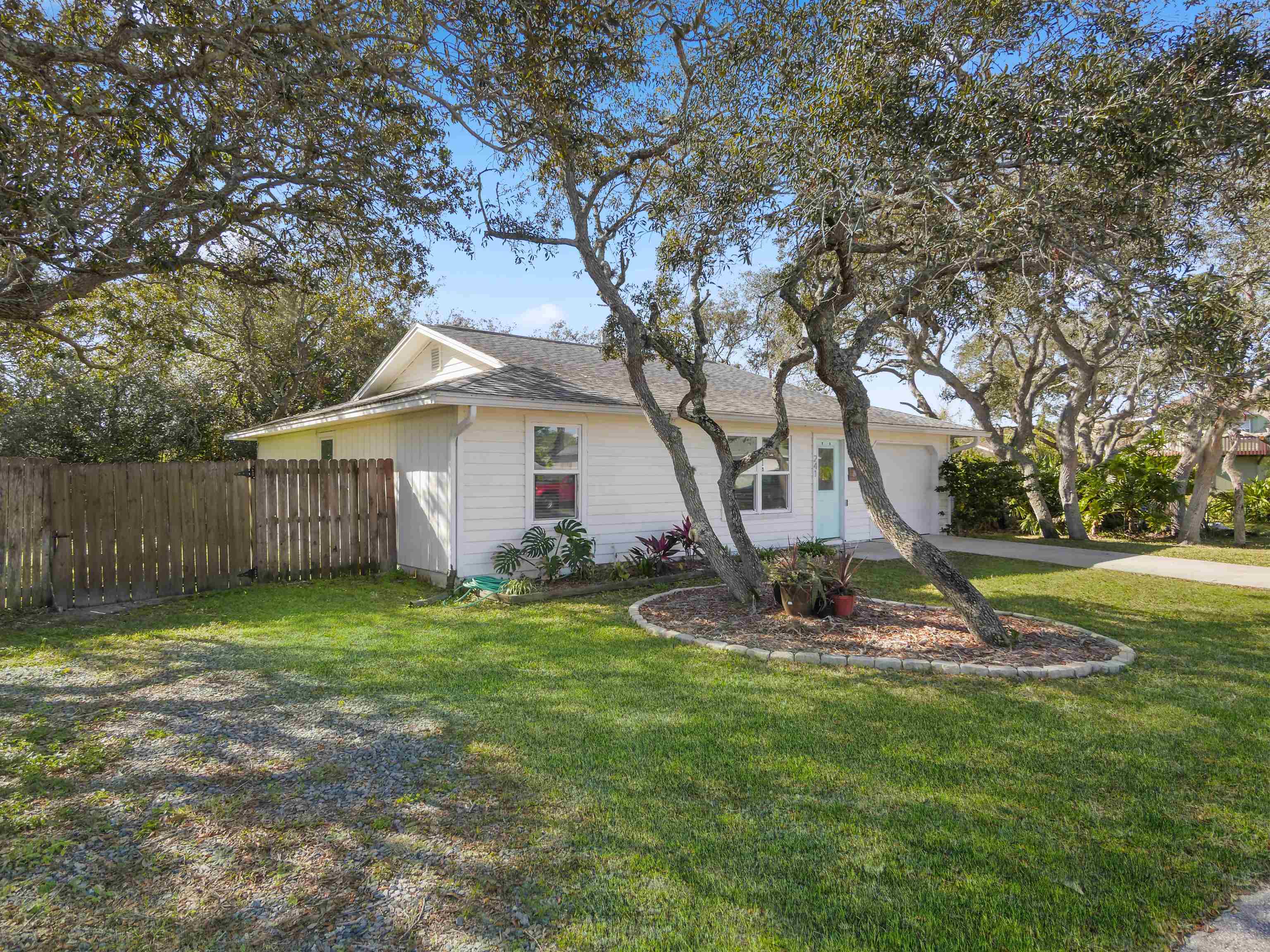 241 Tropic Way St. Augustine, FL 32080 - Photo 5 of 32 a view of a backyard with table and chairs and wooden fence