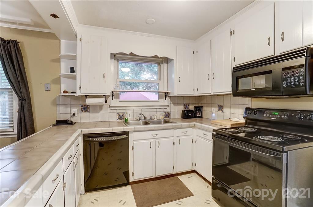 4460 Applegate Road Charlotte, NC 28209 - Photo 13 of 41 a kitchen with stainless steel appliances granite countertop a stove a sink and a microwave