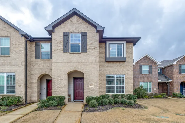 a front view of a house with yard and parking