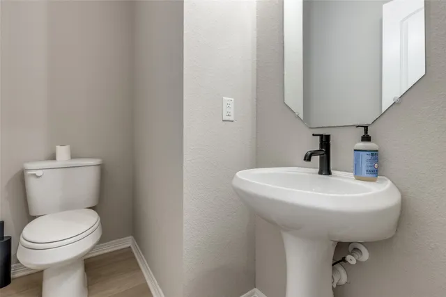 a bathroom with a toilet sink and mirror
