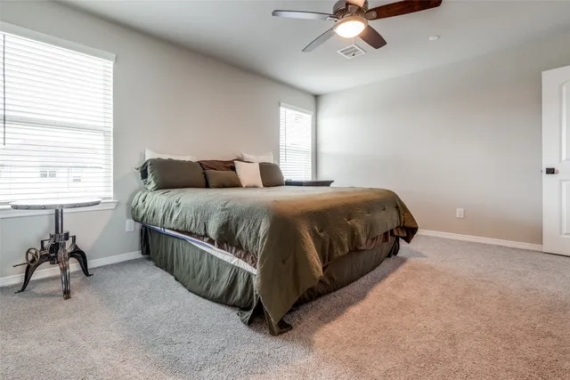 a bedroom with a bed mirror and a window
