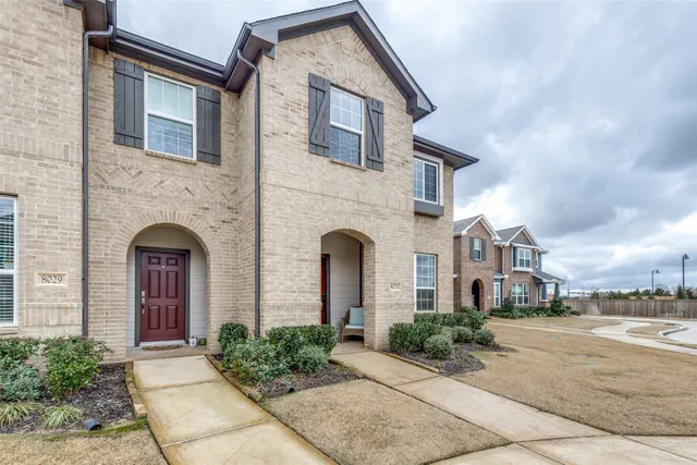 a front view of a house with yard and tress