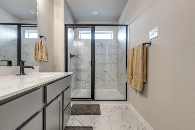 a bathroom with a granite countertop sink a shower and a mirror