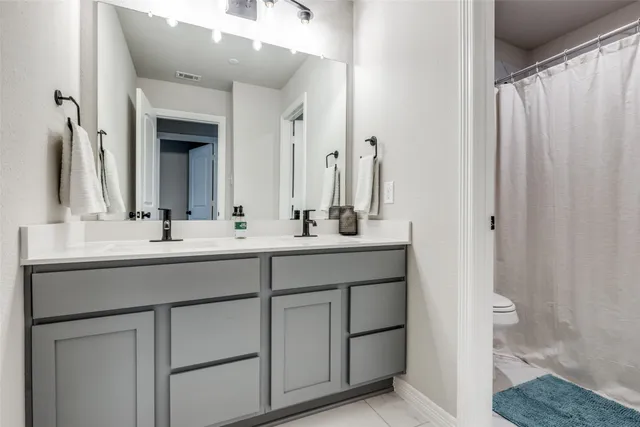 a bathroom with a double vanity sink and a mirror