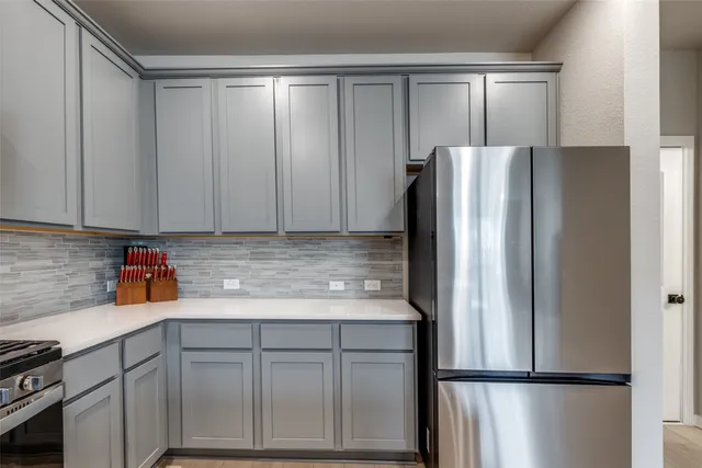 a kitchen with stainless steel appliances granite countertop a refrigerator and a sink