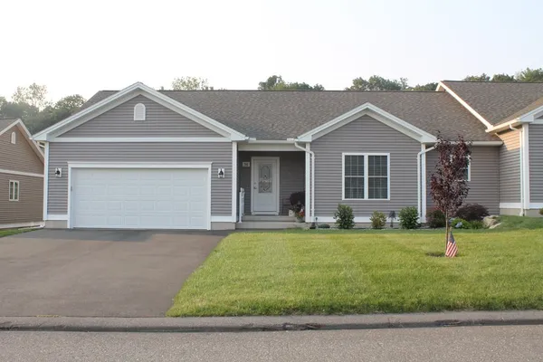 a front view of a house with a garden and yard