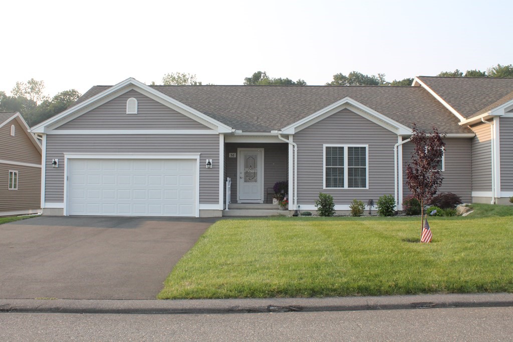 a front view of a house with a garden and yard
