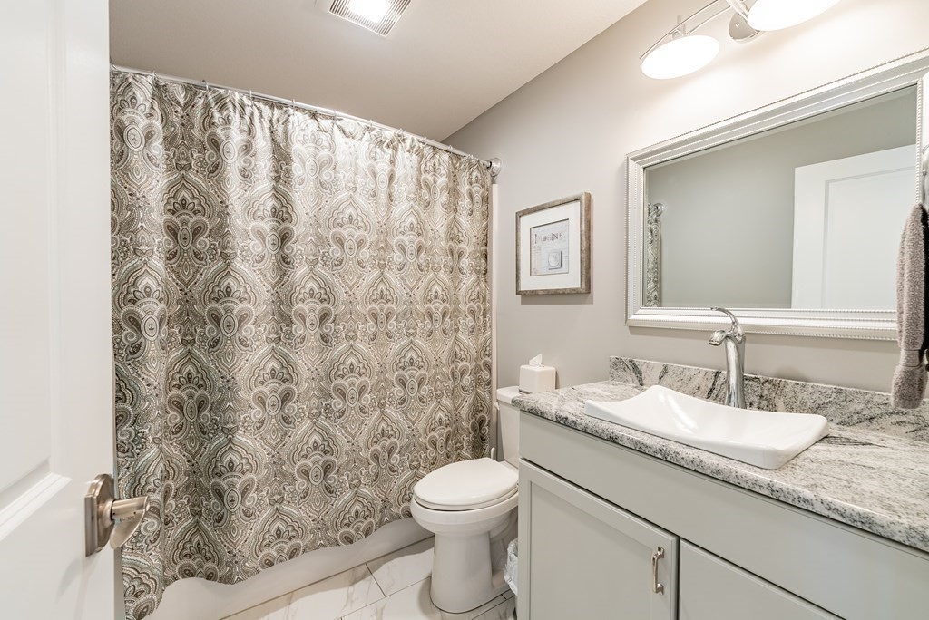 308 Miller Street, Unit 79 Ludlow, MA 01056 - Photo 12 of 20 a bathroom with a granite countertop sink a toilet and a mirror