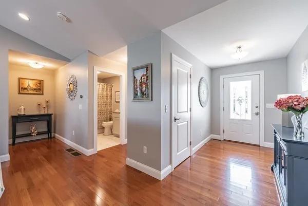 a view of a hallway with wooden floor and a dining room