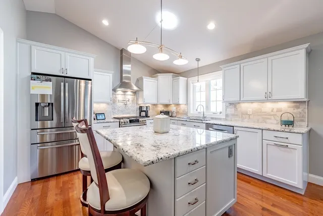 a kitchen with stainless steel appliances granite countertop a sink refrigerator and cabinets