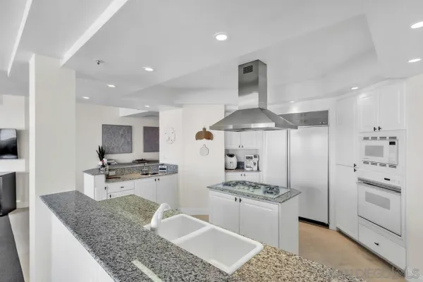 a living room with granite countertop a couch and potted plant