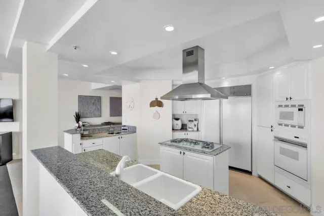 a living room with granite countertop a couch and potted plant