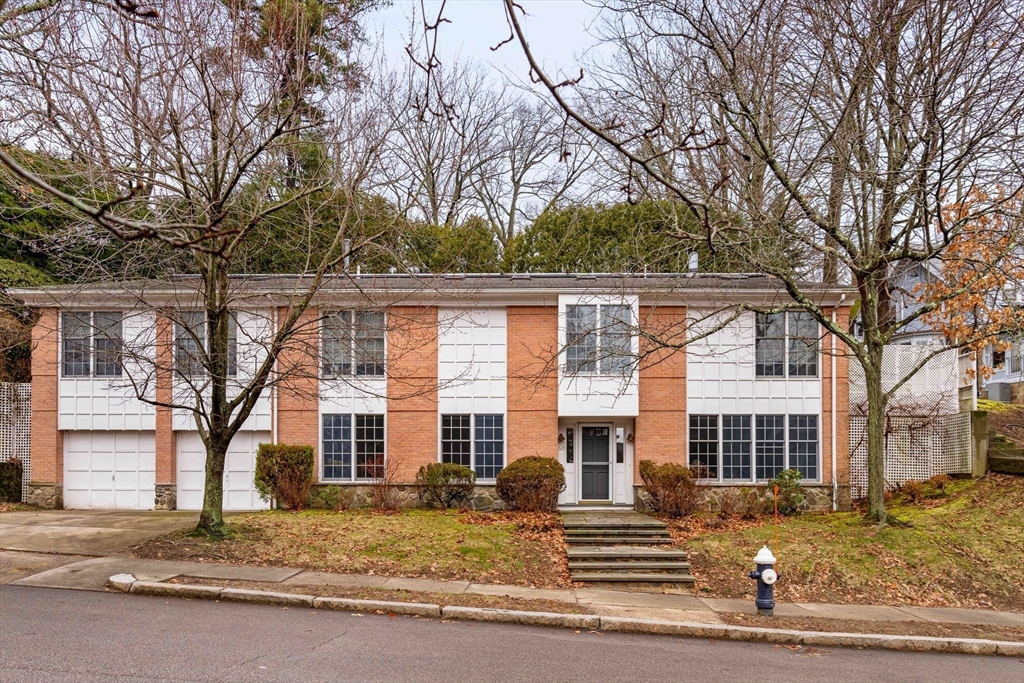 63 Rawson Road Brookline, MA 02445 - Photo 1 of 1 a front view of a house with a tree